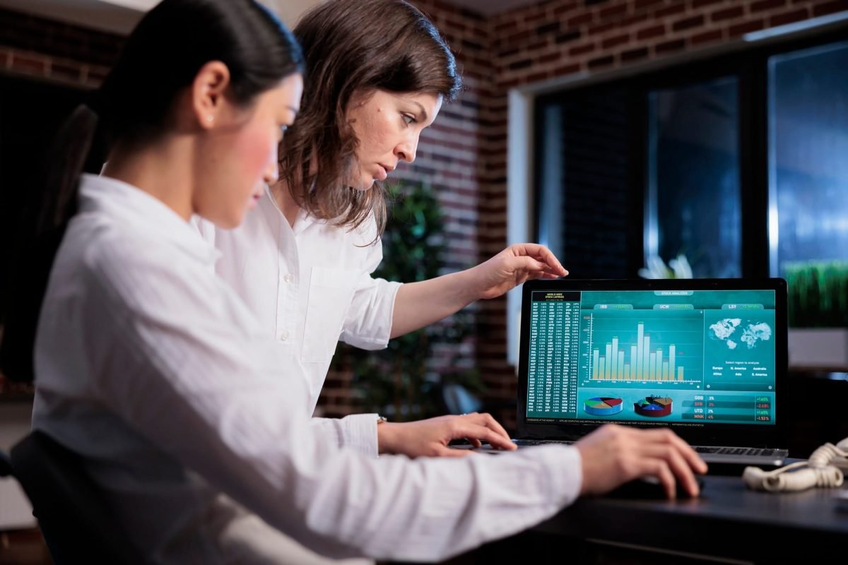 Marketing agency employees discussing about bankruptcy while analyzing financial data on laptop screen. Marketing agency employees discussing about bankruptcy while analyzing financial data on laptop screen. Business company office workers sitting at desk while reviewing startup project state.